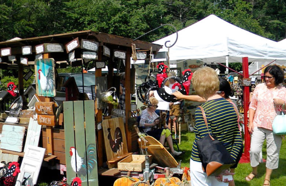 People perusing handmade art at an outdoor festival